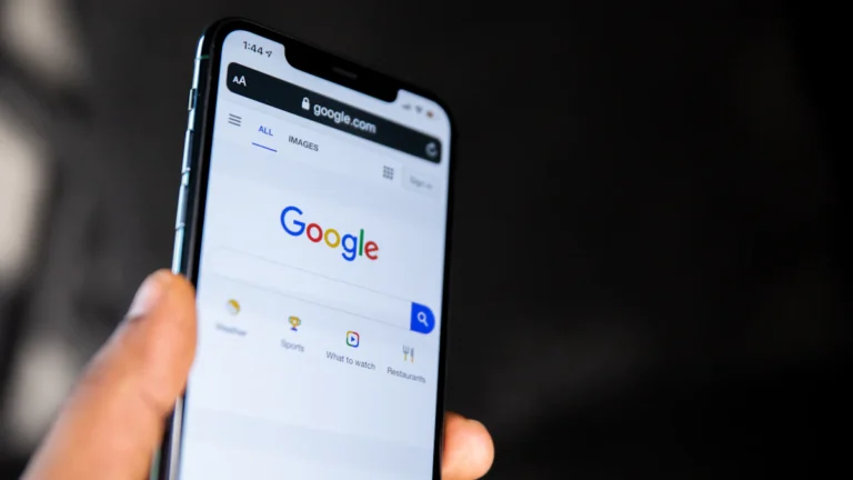 Hand holding a smartphone showing Google search